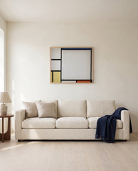 Blue, Red, Yellow and Black by Piet Mondrian framed in natural oak above a cream sofa in a warm living room