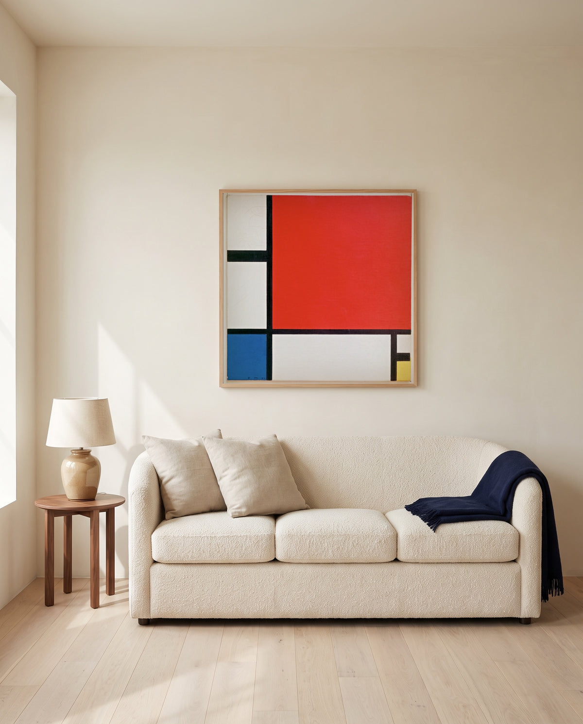 Composition II by Piet Mondrian framed in natural oak above a cream sofa in a warm living room