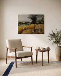 The Harvesters by Pieter Bruegel the Elder as a stretched canvas above a linen lounge chair in a reading corner