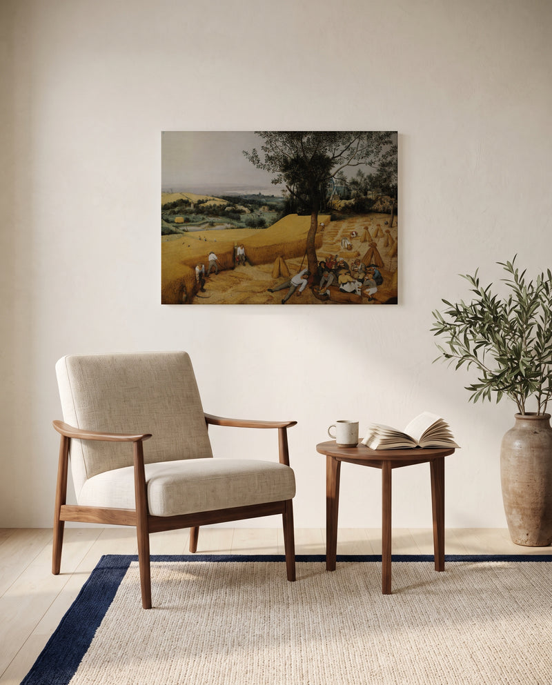 The Harvesters by Pieter Bruegel the Elder as a stretched canvas above a linen lounge chair in a reading corner