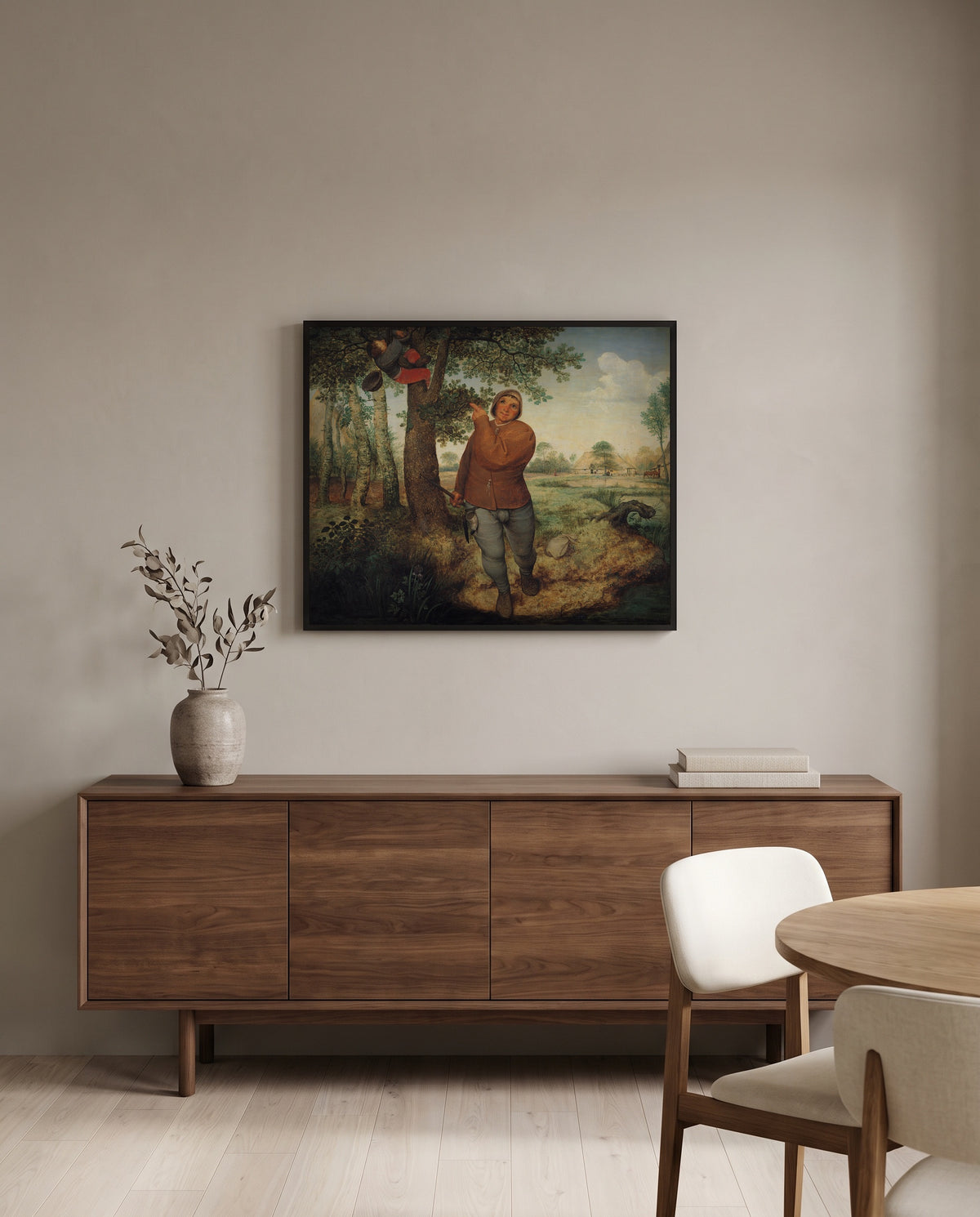 The Nest Robber by Pieter Bruegel the Elder in a black frame above a walnut sideboard in a dining room