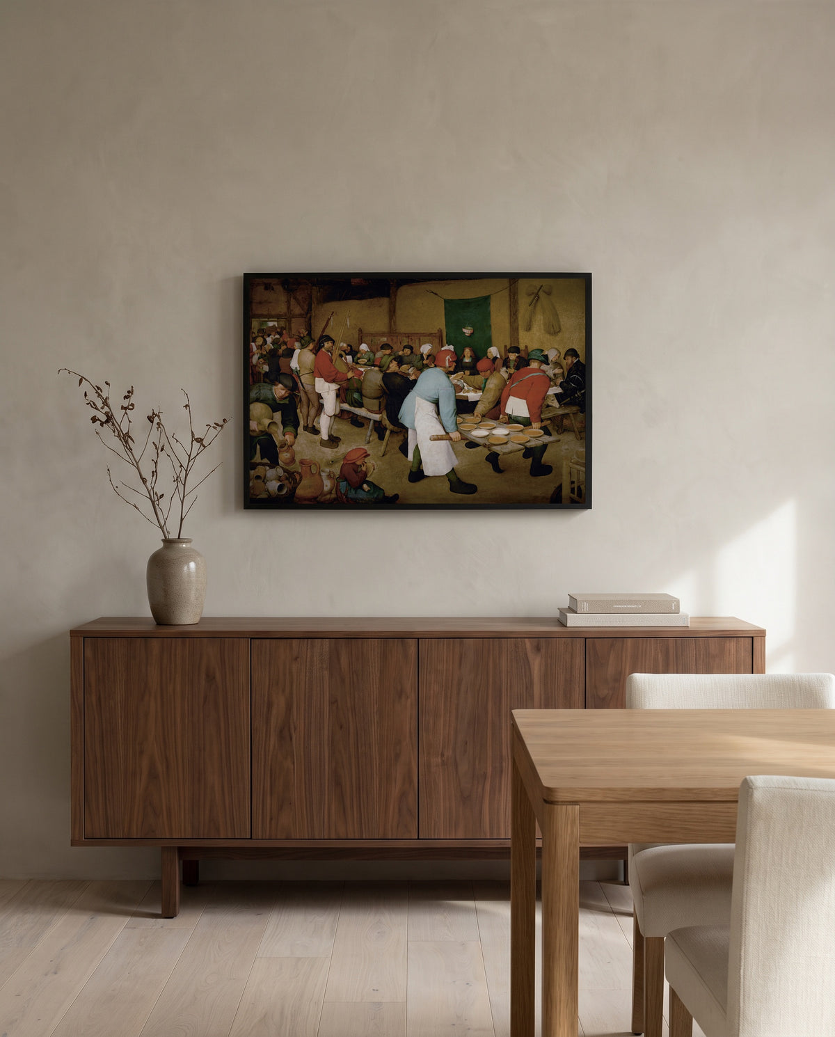 The Peasant Wedding by Pieter Bruegel the Elder in a black frame above a walnut sideboard in a dining room