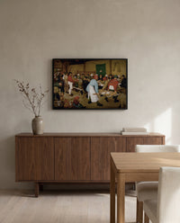 The Peasant Wedding by Pieter Bruegel the Elder in a black frame above a walnut sideboard in a dining room
