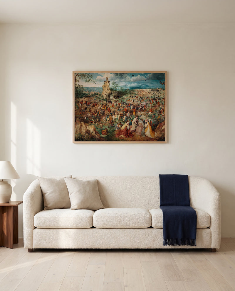 The Procession to Calvary by Pieter Bruegel the Elder framed in natural oak above a cream sofa in a warm living room