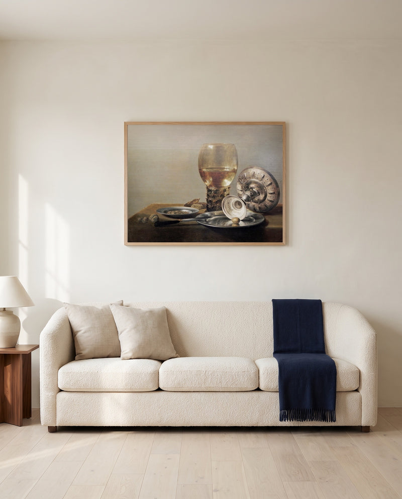 Roemer and Silver Bowl by Pieter Claesz framed in natural oak above a cream sofa in a warm living room