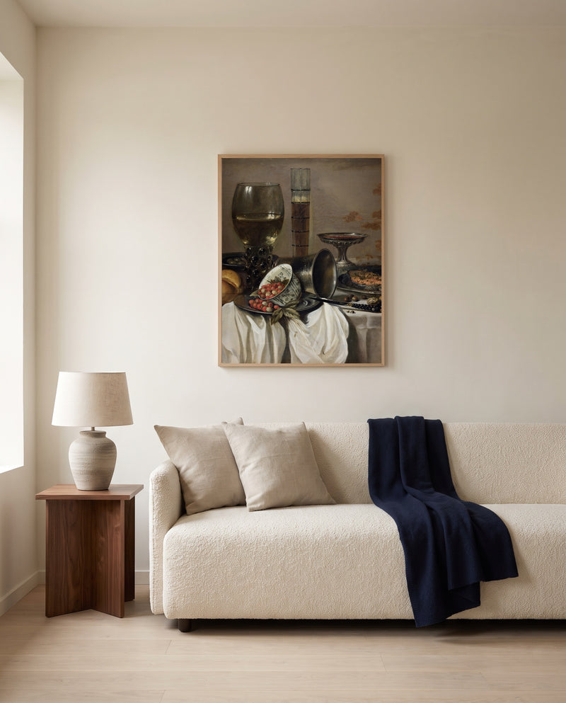 Drinking Vessels by Pieter Claesz framed in natural oak above a cream sofa in a warm living room