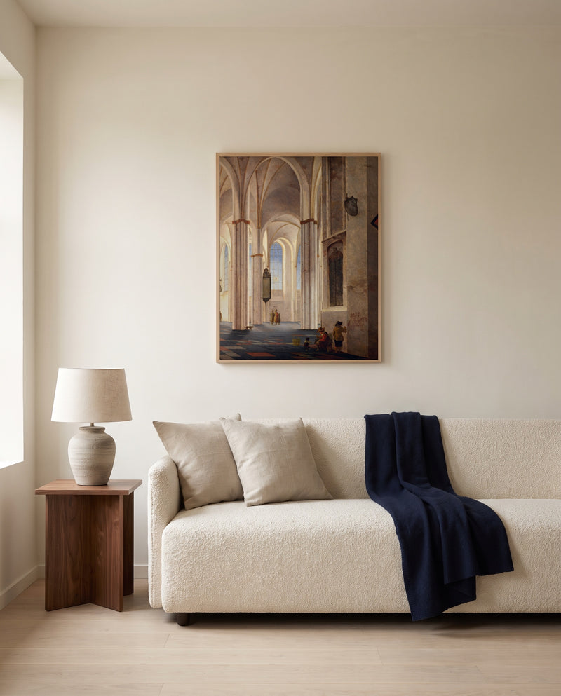 Buurkerk, Utrecht by Pieter Saenredam framed in natural oak above a cream sofa in a warm living room