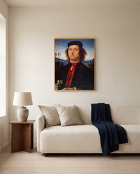 Francesco delle Opere by Pietro Perugino framed in natural oak above a cream sofa in a warm living room