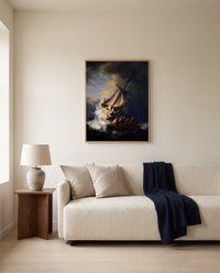The Storm on the Sea of Galilee by Rembrandt framed in natural oak above a cream sofa in a warm living room