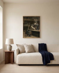 Between Rounds by Thomas Eakins framed in natural oak above a cream sofa in a warm living room