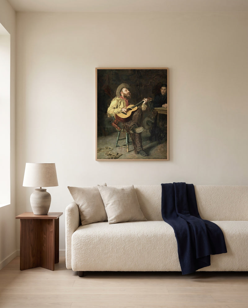 Home Ranch by Thomas Eakins framed in natural oak above a cream sofa in a warm living room