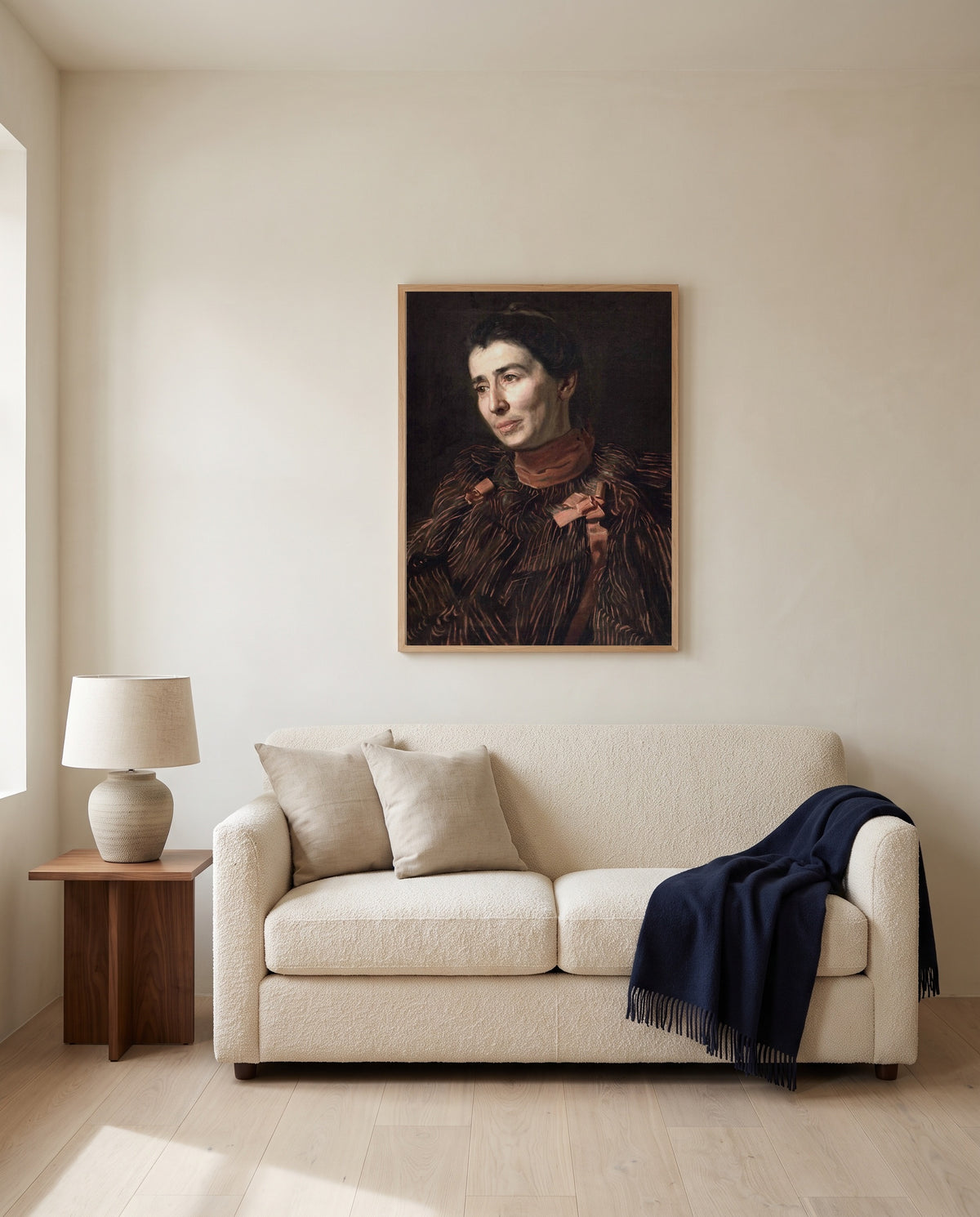 Mary Adeline Williams by Thomas Eakins framed in natural oak above a cream sofa in a warm living room