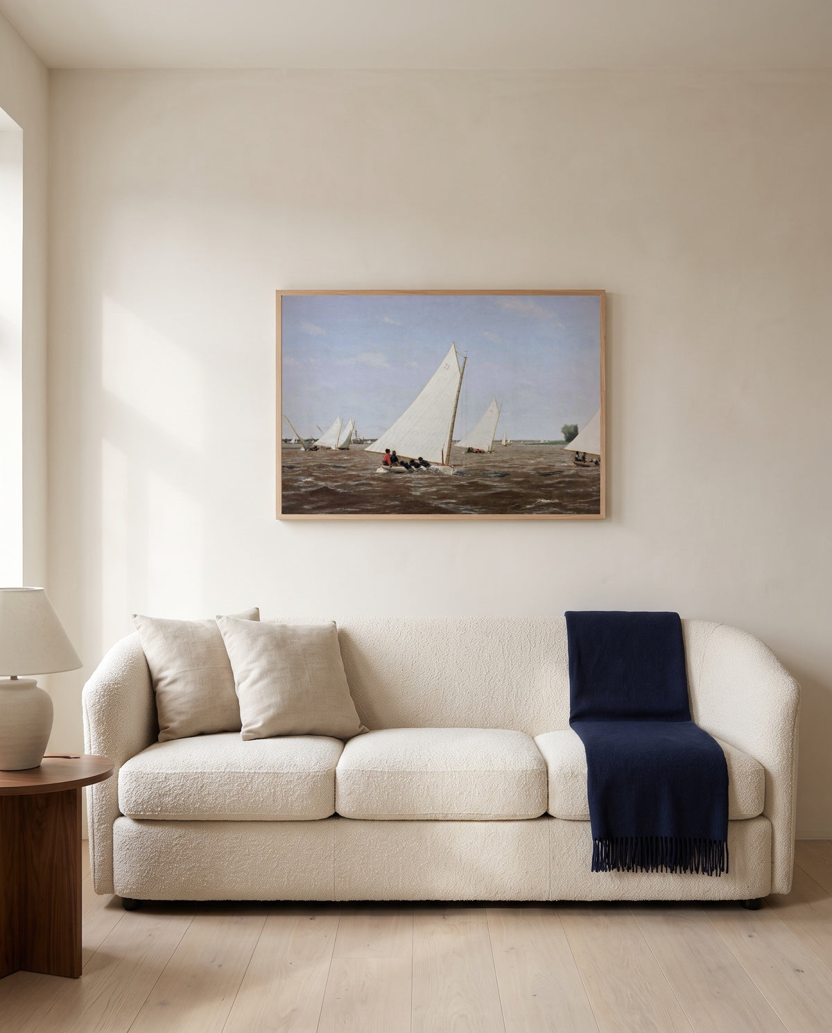 Sailboats Racing by Thomas Eakins framed in natural oak above a cream sofa in a warm living room