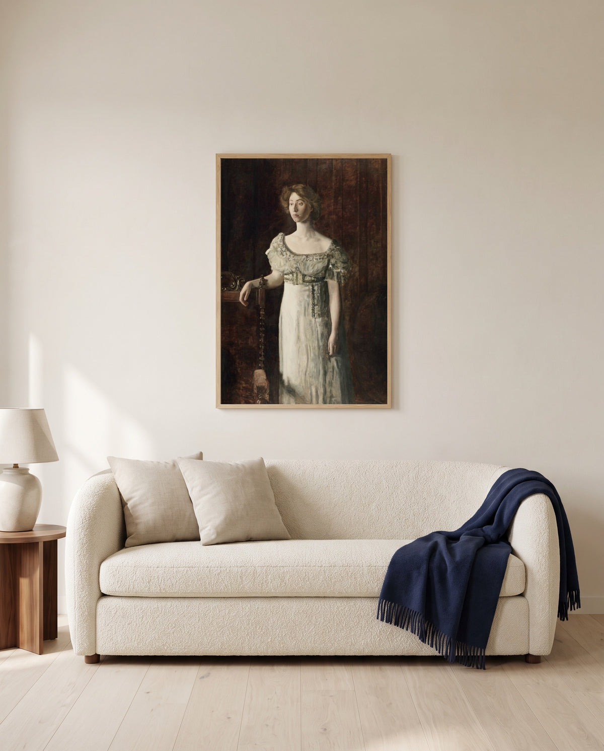The Old-Fashioned Dress by Thomas Eakins framed in natural oak above a cream sofa in a warm living room