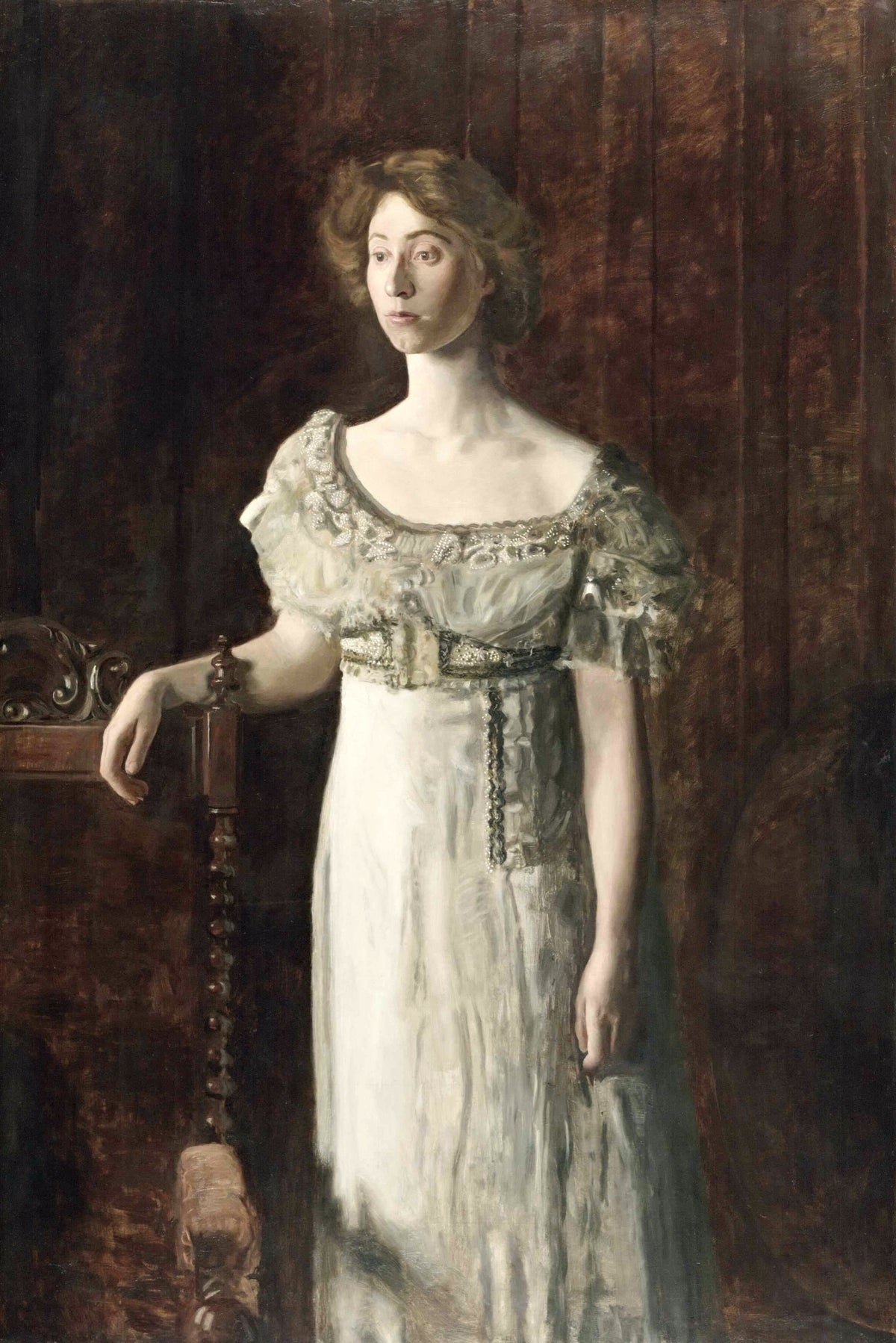 The Old-Fashioned Dress by Thomas Eakins: a young woman in a pale beaded gown stands by a carved chair against a dark wall
