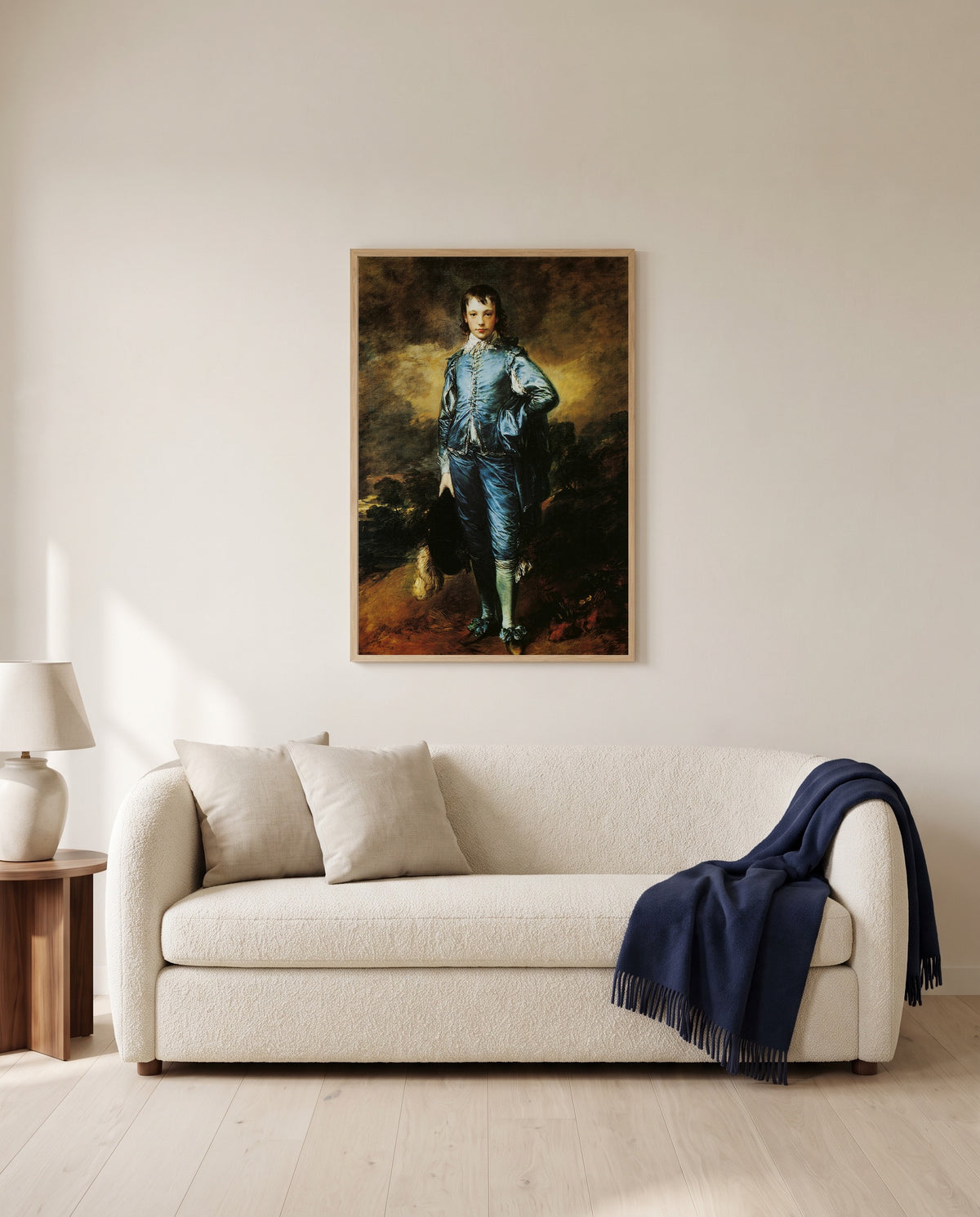 The Blue Boy by Thomas Gainsborough framed in natural oak above a cream sofa in a warm living room