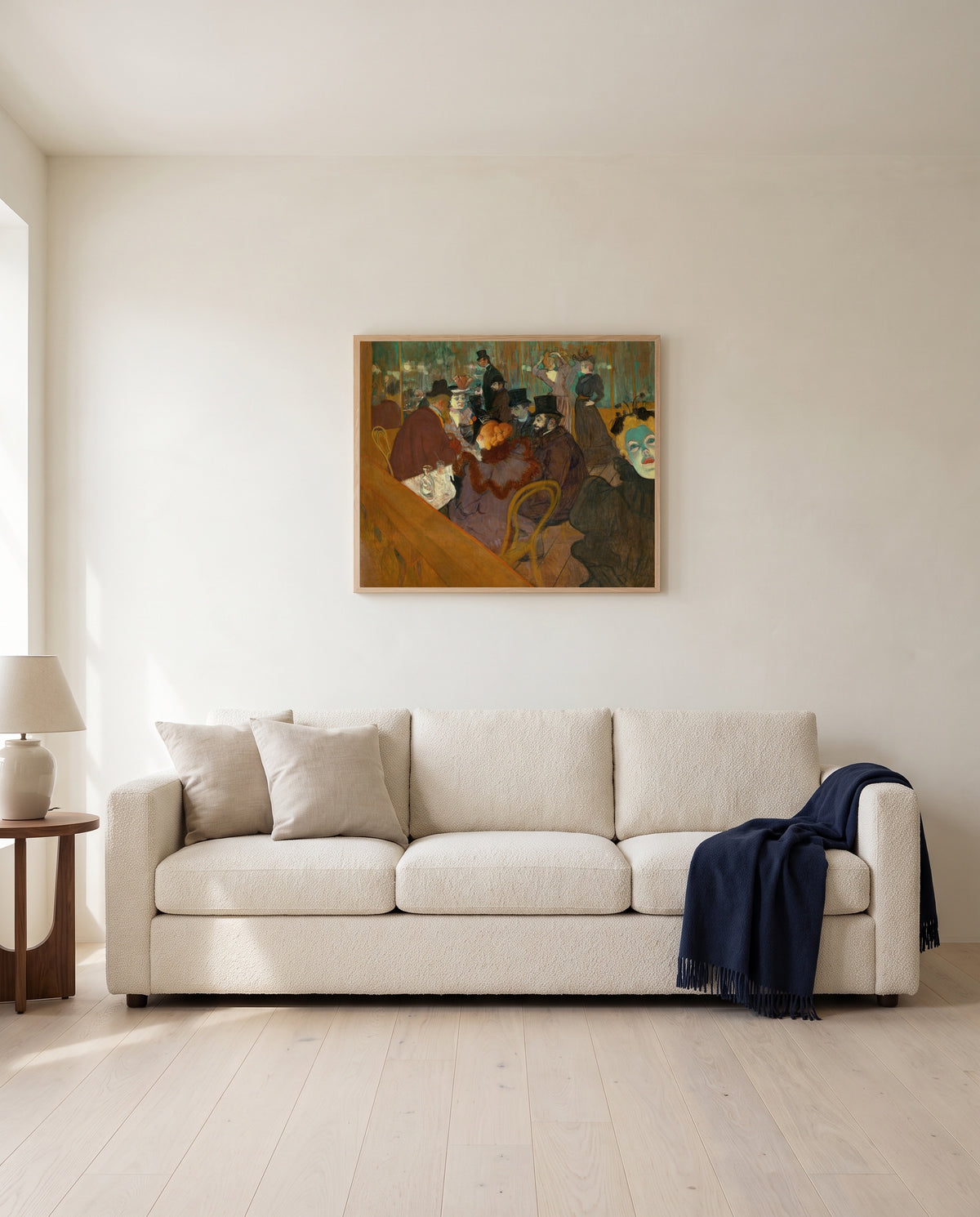 At the Moulin Rouge by Henri de Toulouse-Lautrec framed in natural oak above a cream sofa in a warm living room