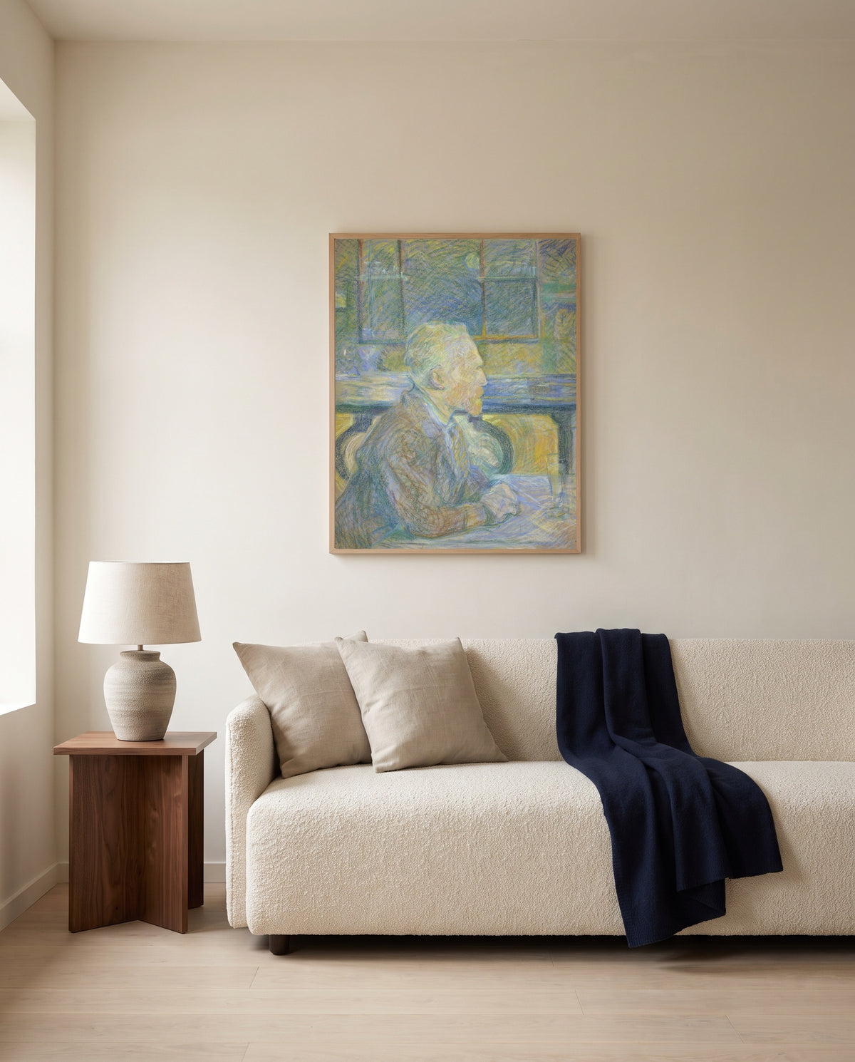 Portrait of Van Gogh by Henri de Toulouse-Lautrec framed in natural oak above a cream sofa in a warm living room