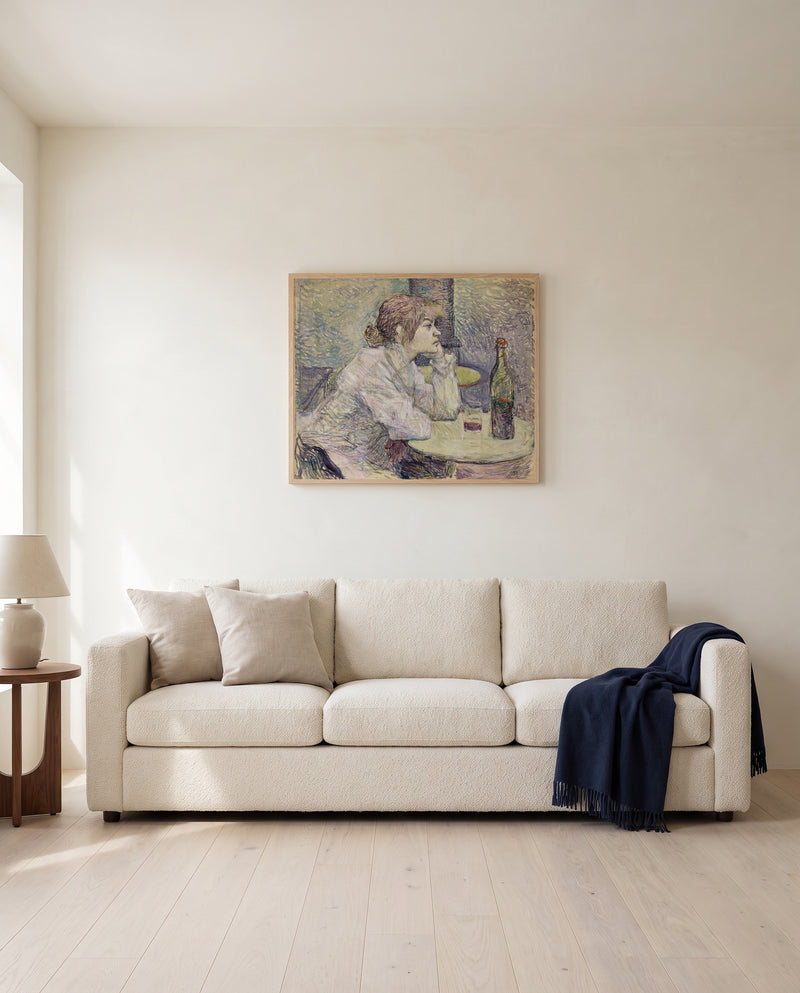 The Hangover by Henri de Toulouse-Lautrec framed in natural oak above a cream sofa in a warm living room