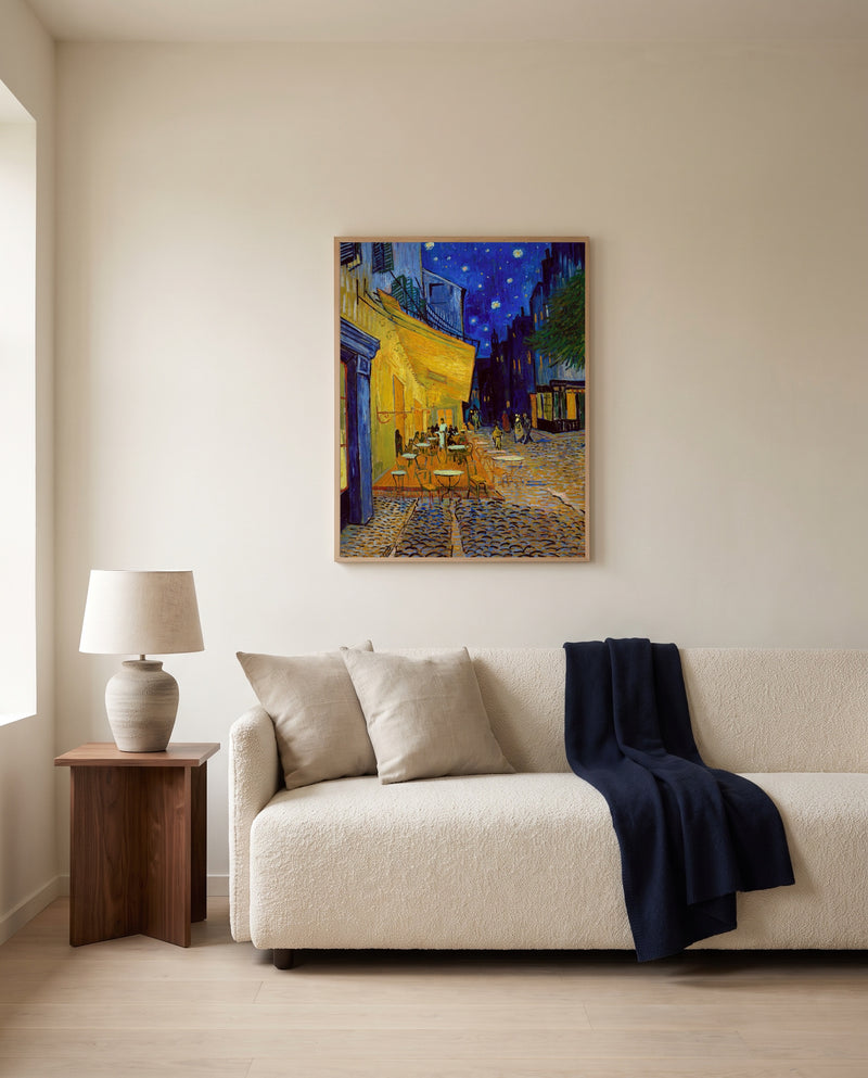 Café Terrace at Night by Vincent van Gogh framed in natural oak above a cream sofa in a warm living room