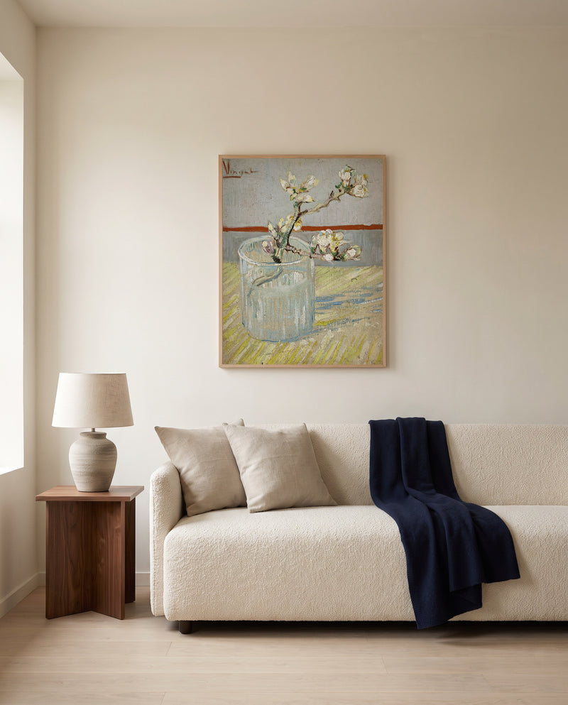 Almond Branch in a Glass by Vincent van Gogh framed in natural oak above a cream sofa in a warm living room