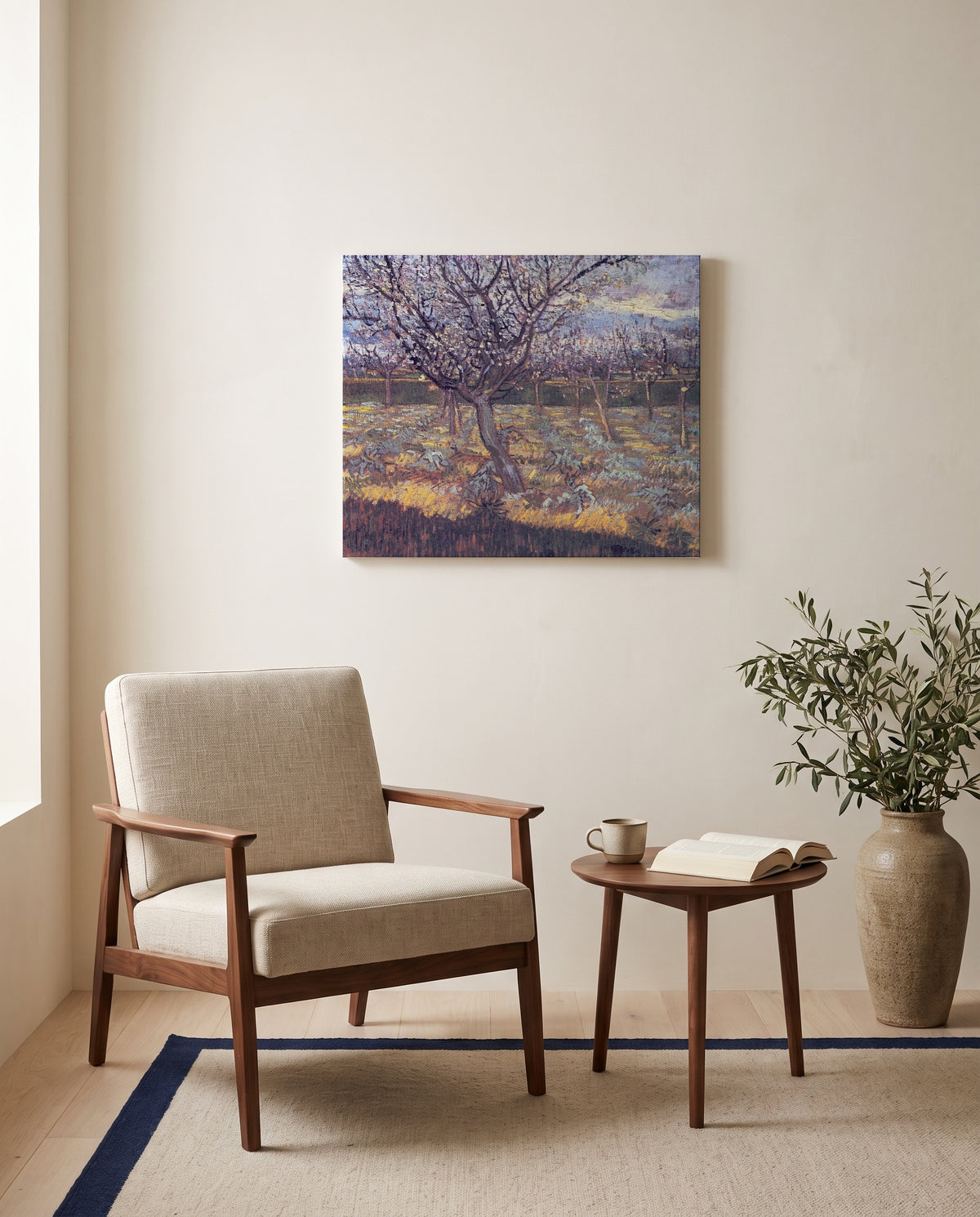 Apricot Trees in Blossom by Vincent van Gogh as a stretched canvas above a linen lounge chair in a reading corner