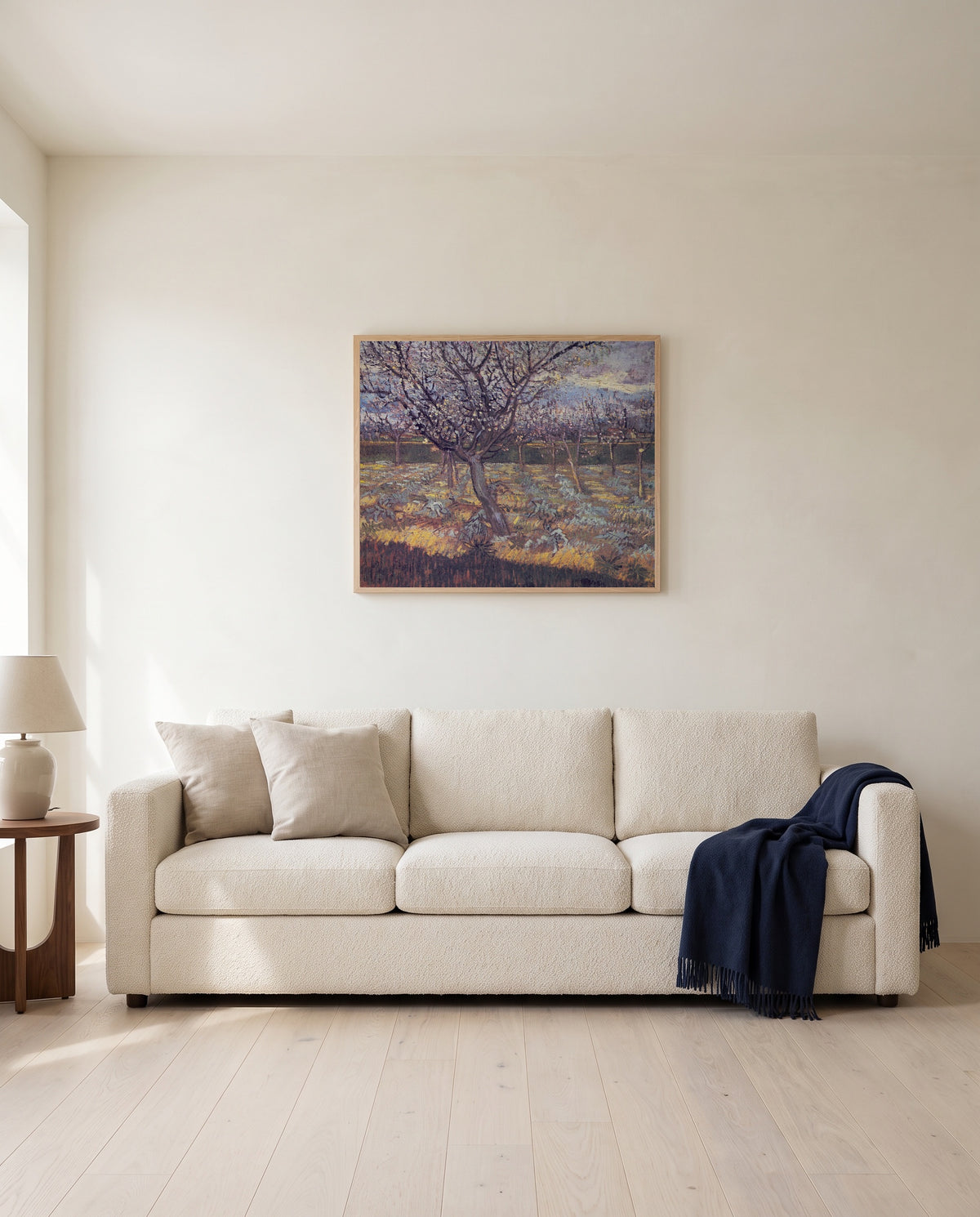 Apricot Trees in Blossom by Vincent van Gogh framed in natural oak above a cream sofa in a warm living room
