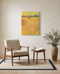 Arles: View from the Wheat Fields by Vincent van Gogh as a stretched canvas above a linen lounge chair in a reading corner