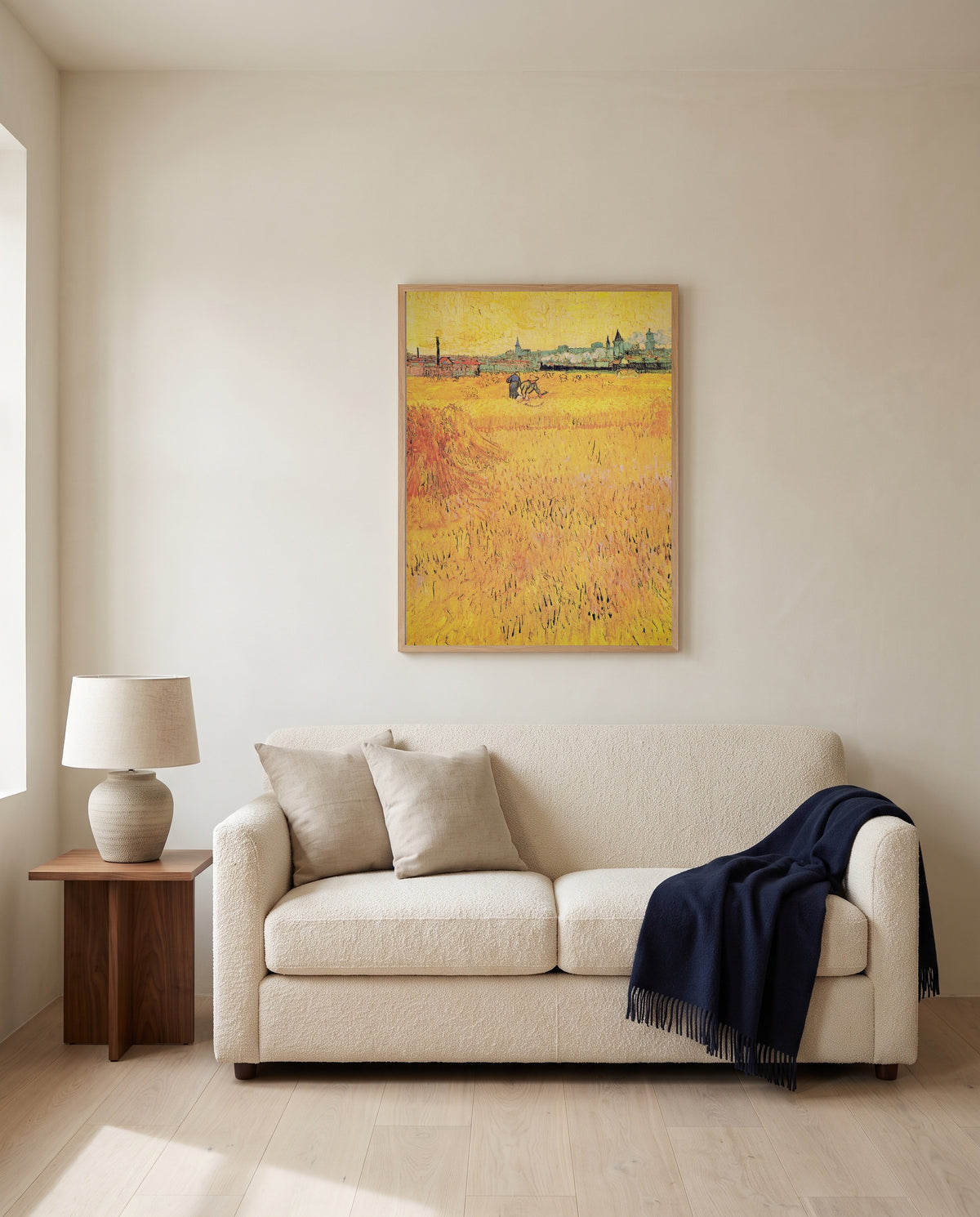 Arles: View from the Wheat Fields by Vincent van Gogh framed in natural oak above a cream sofa in a warm living room