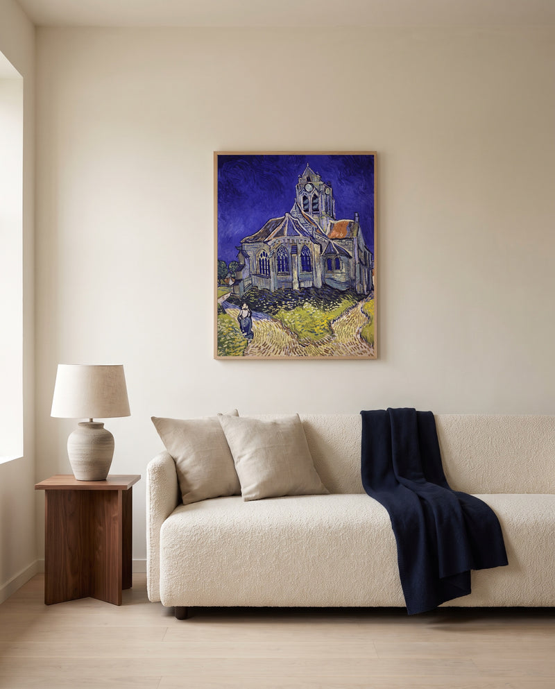 The Church at Auvers by Vincent van Gogh framed in natural oak above a cream sofa in a warm living room