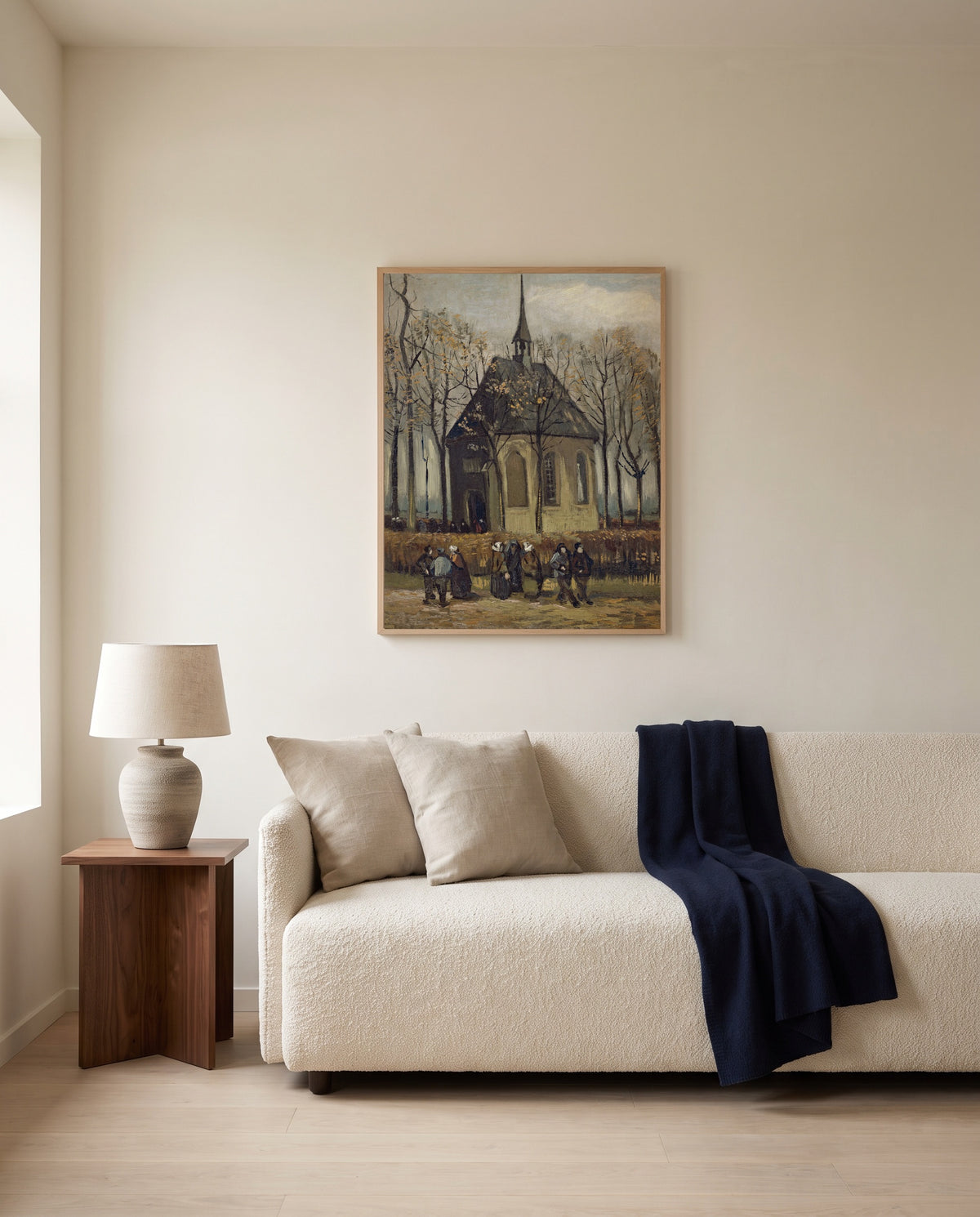 Congregation Leaving the Church by Vincent van Gogh framed in natural oak above a cream sofa in a warm living room