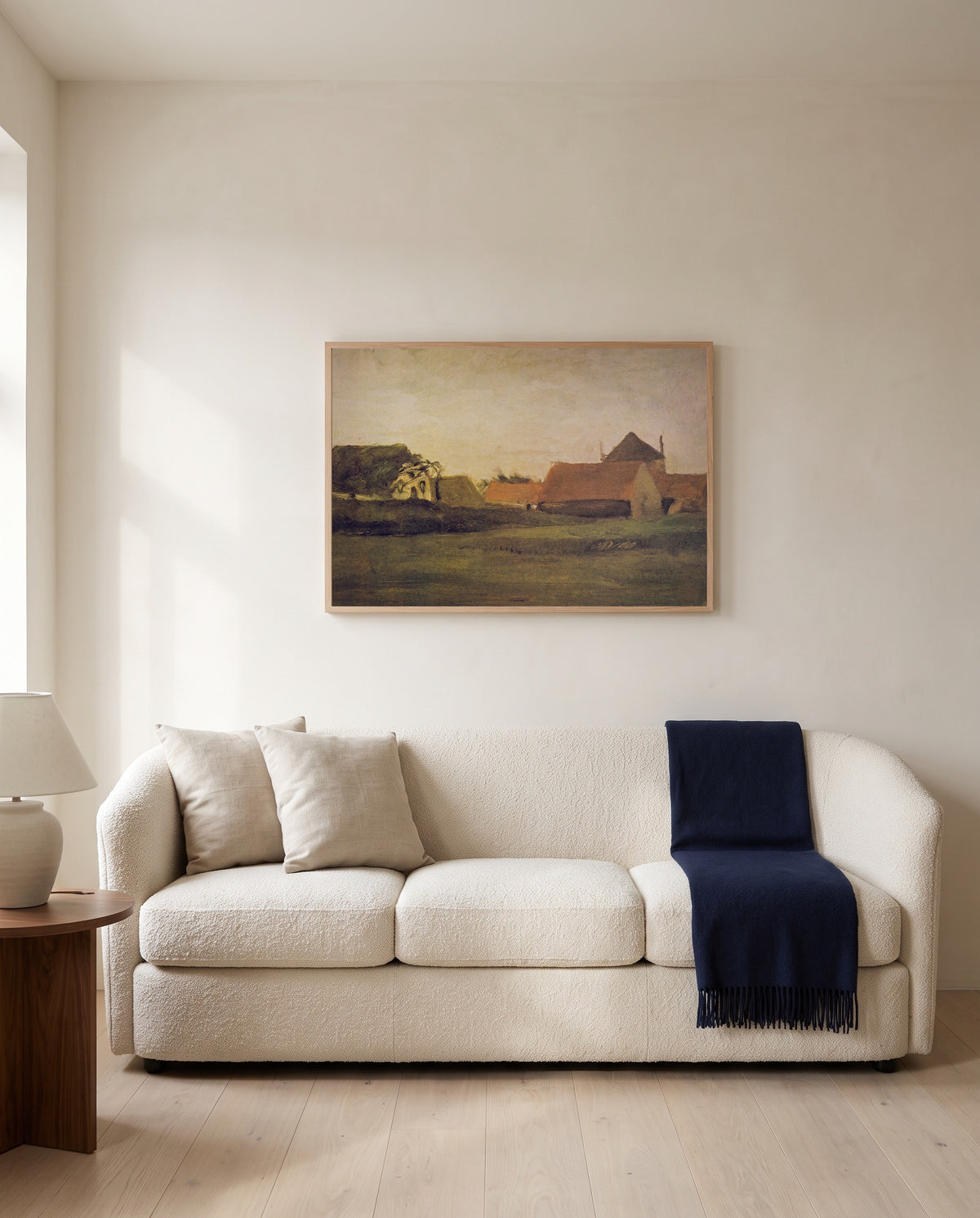 Farmhouses in Loosduinen by Vincent van Gogh framed in natural oak above a cream sofa in a warm living room