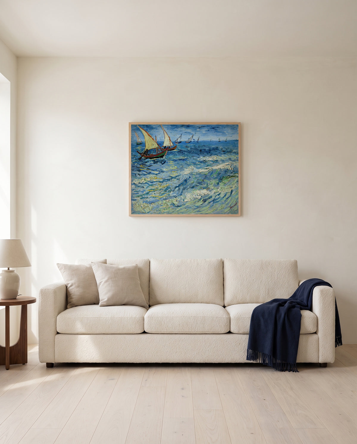 Fishing Boats at Sea by Vincent van Gogh framed in natural oak above a cream sofa in a warm living room