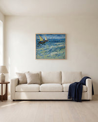 Fishing Boats at Sea by Vincent van Gogh framed in natural oak above a cream sofa in a warm living room