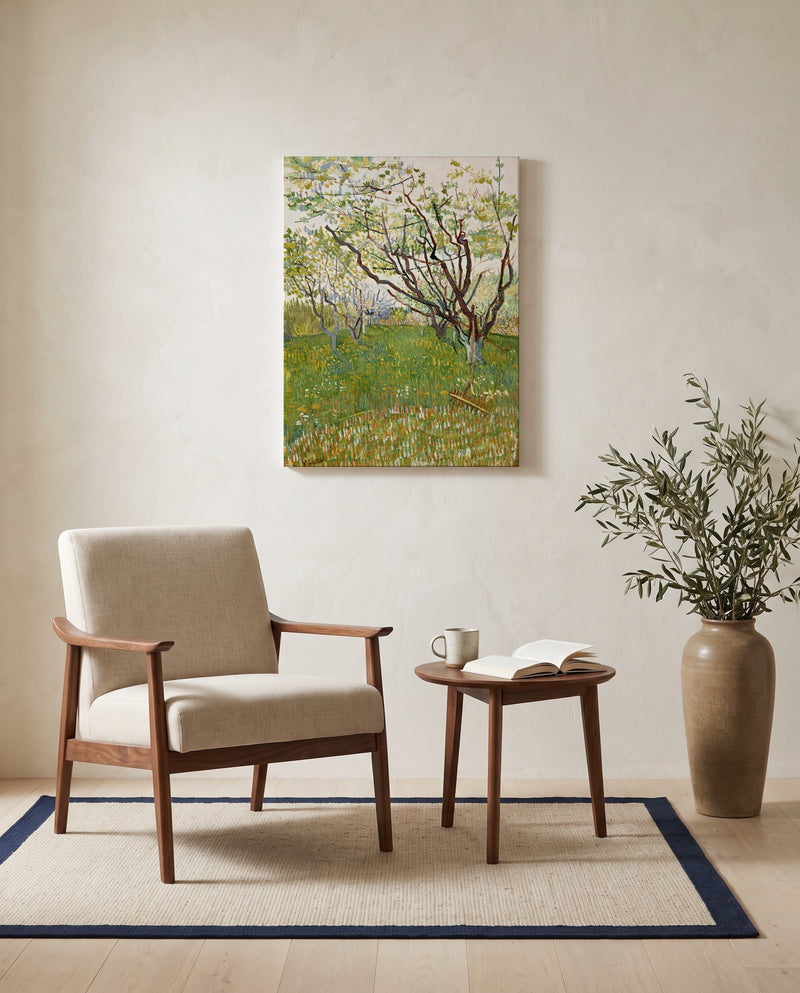 The Flowering Orchard by Vincent van Gogh as a stretched canvas above a linen lounge chair in a reading corner