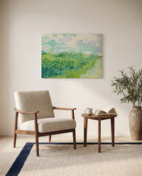 Green Wheat Fields, Auvers by Vincent van Gogh as a stretched canvas above a linen lounge chair in a reading corner