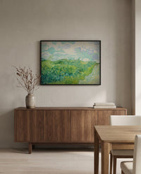 Green Wheat Fields, Auvers by Vincent van Gogh in a black frame above a walnut sideboard in a dining room