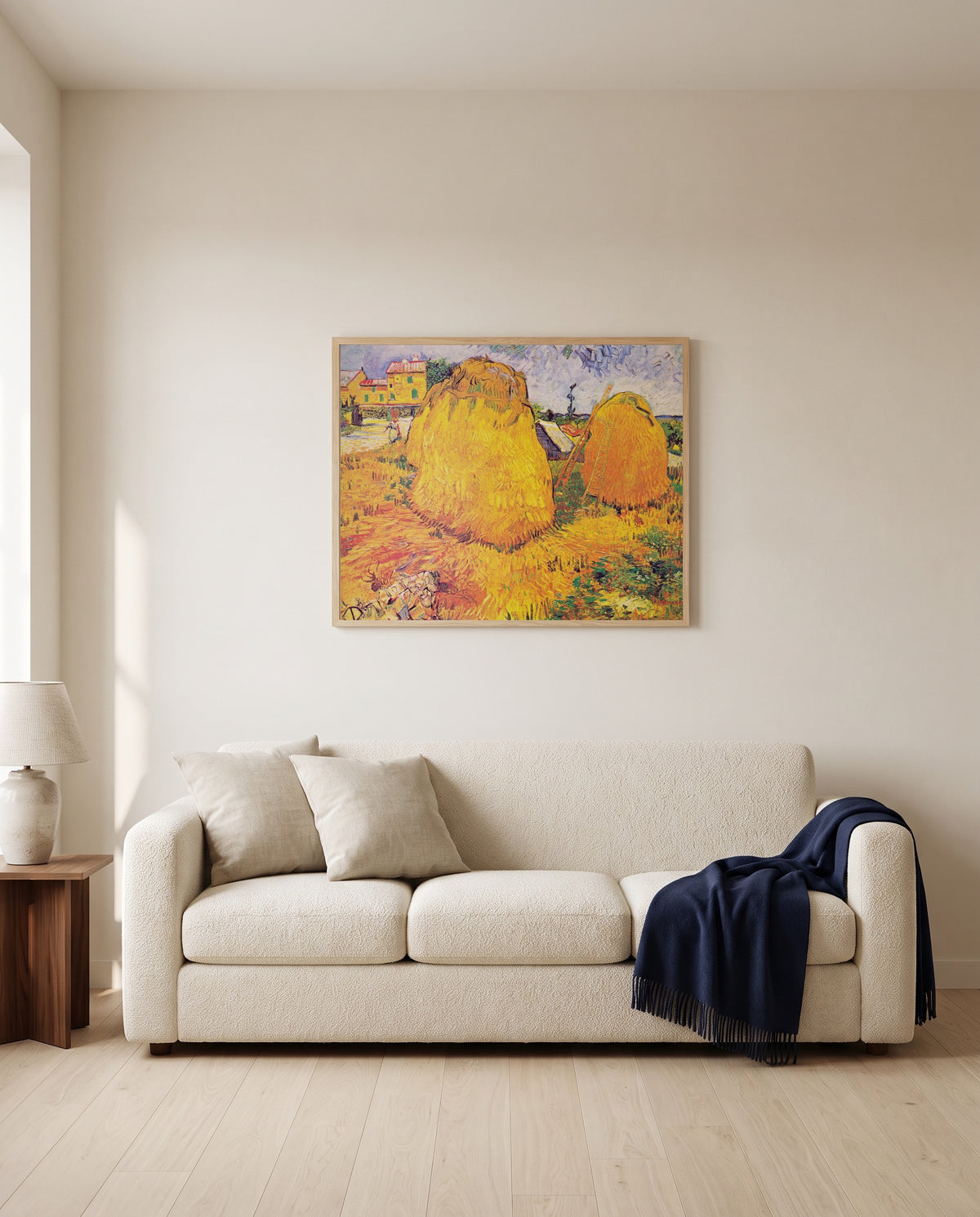 Haystacks in Provence by Vincent van Gogh framed in natural oak above a cream sofa in a warm living room