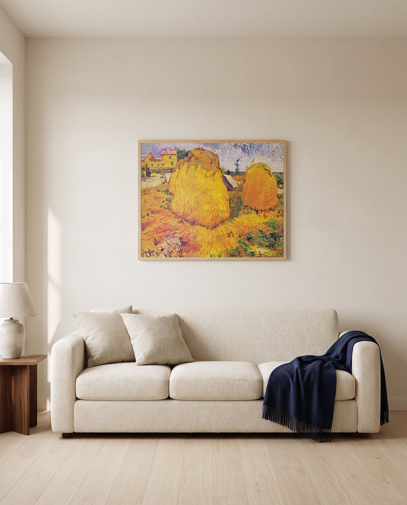 Haystacks in Provence by Vincent van Gogh framed in natural oak above a cream sofa in a warm living room