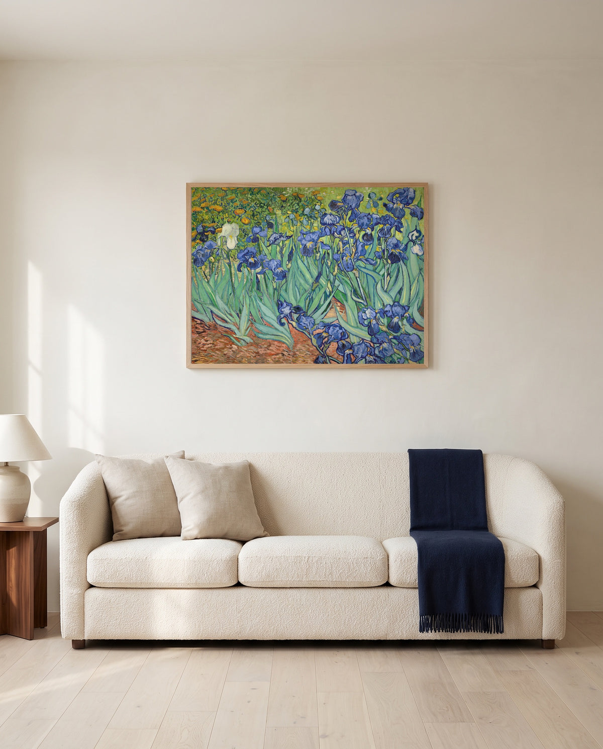 Irises by Vincent van Gogh framed in natural oak above a cream sofa in a warm living room