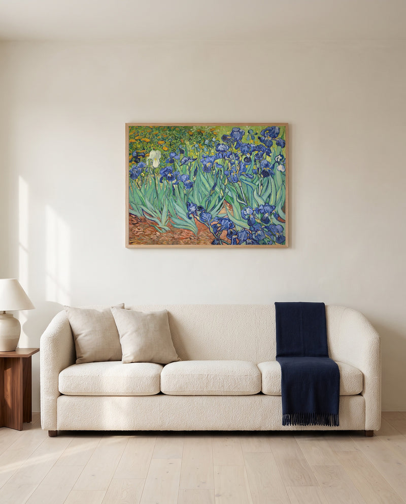 Irises by Vincent van Gogh framed in natural oak above a cream sofa in a warm living room