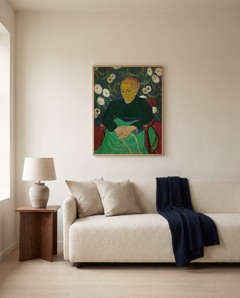 La Berceuse by Vincent van Gogh framed in natural oak above a cream sofa in a warm living room