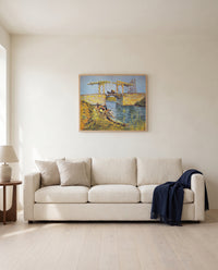 The Langlois Bridge by Vincent van Gogh framed in natural oak above a cream sofa in a warm living room