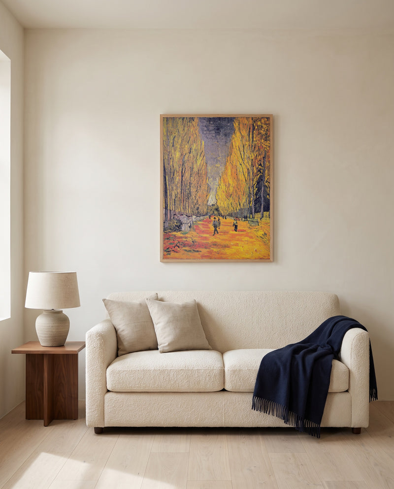 Les Alyscamps by Vincent van Gogh framed in natural oak above a cream sofa in a warm living room