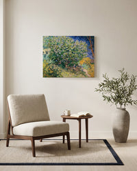 Lilac Bush by Vincent van Gogh as a stretched canvas above a linen lounge chair in a reading corner