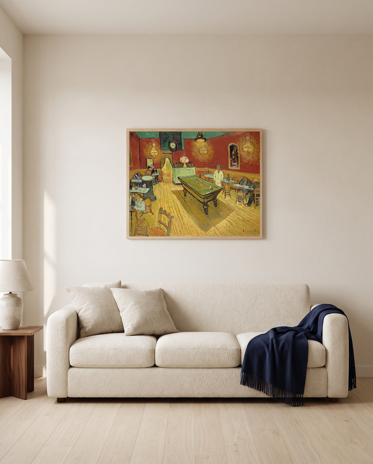 The Night Café by Vincent van Gogh framed in natural oak above a cream sofa in a warm living room