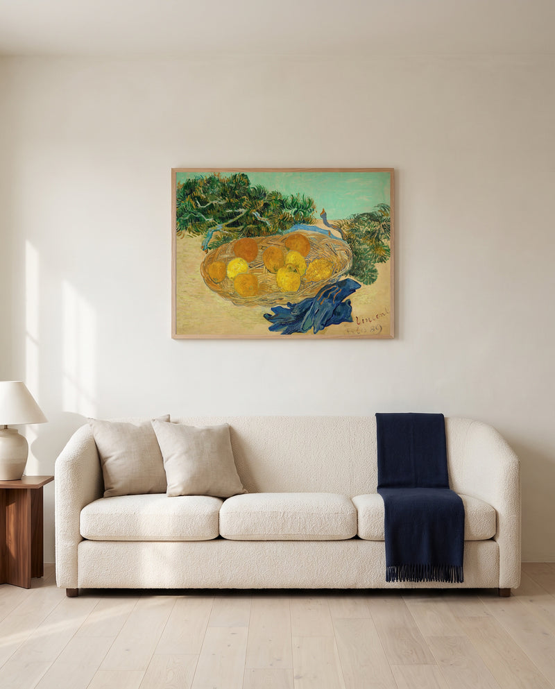 Oranges and Lemons with Blue Gloves by Vincent van Gogh framed in natural oak above a cream sofa in a warm living room