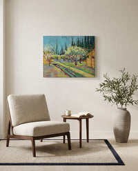 Orchard Bordered by Cypresses by Vincent van Gogh as a stretched canvas above a linen lounge chair in a reading corner