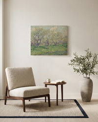 Orchard in Blossom, 1889 by Vincent van Gogh as a stretched canvas above a linen lounge chair in a reading corner