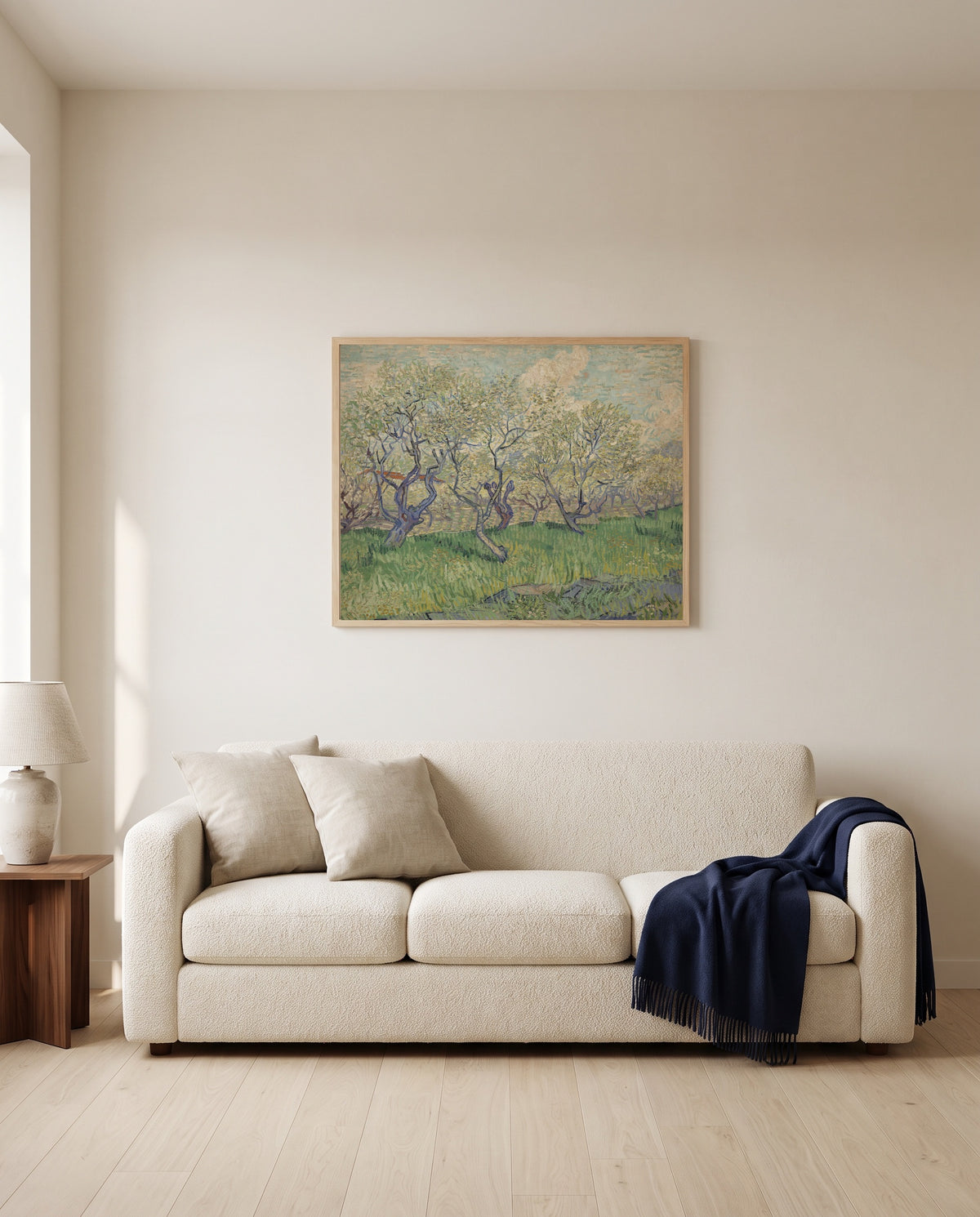 Orchard in Blossom, 1889 by Vincent van Gogh framed in natural oak above a cream sofa in a warm living room